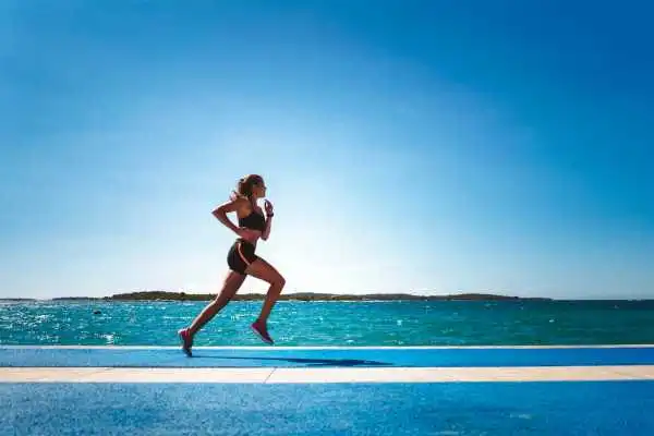 Woman running showing strong leg muscle Lichfield